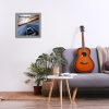Minimalistic interior design concept. Acoustic guitar on grey textile sofa in spacious room of loft style apartment with wood textured laminated flooring. Background, copy space, close up.