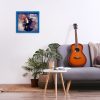 Minimalistic interior design concept. Acoustic guitar on grey textile sofa in spacious room of loft style apartment with wood textured laminated flooring. Background, copy space, close up.